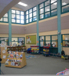 Image of library, high ceiling, rows of books and windows